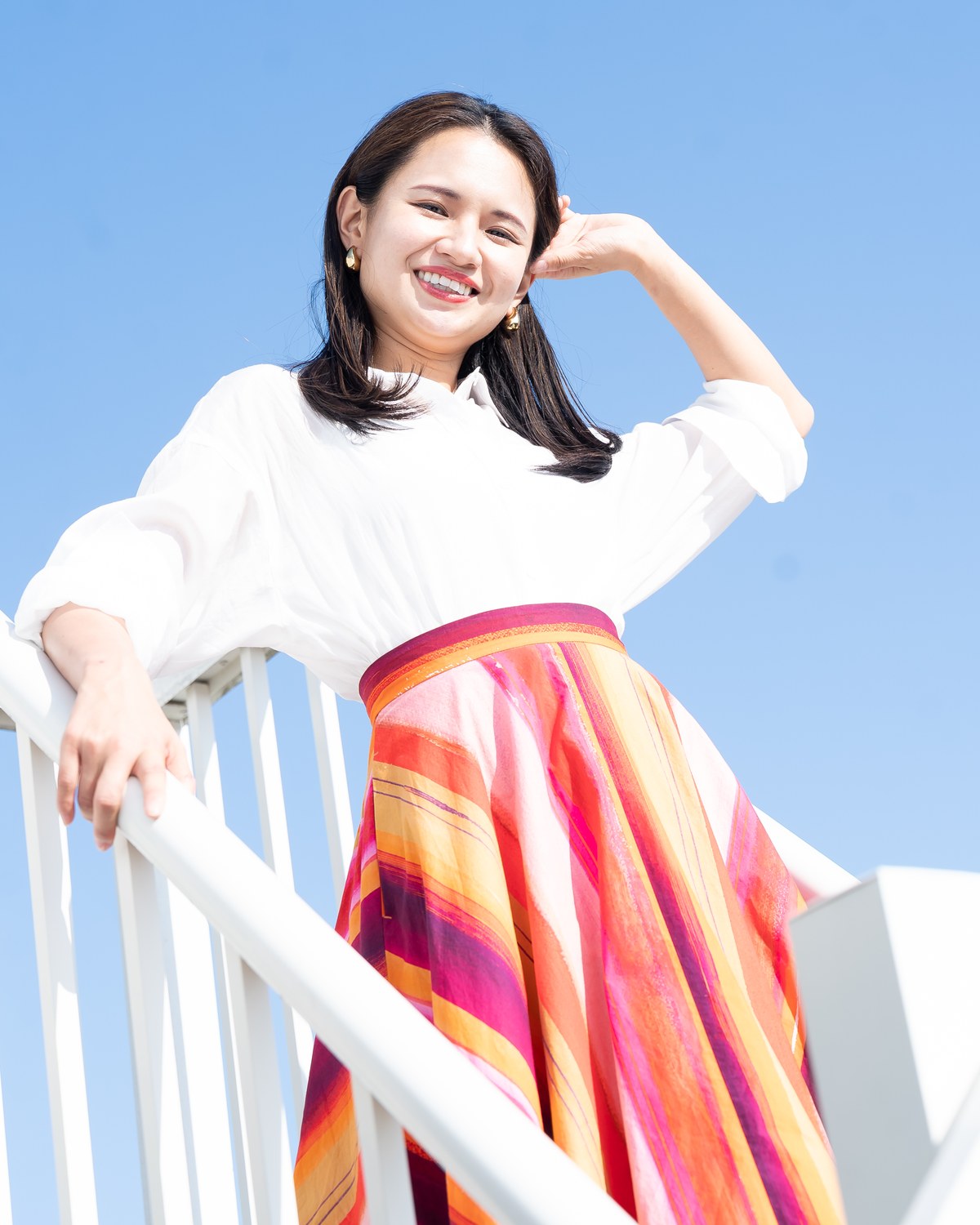 青空の下、笑顔の山口聖子